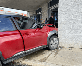 red car crashing into corner of the store